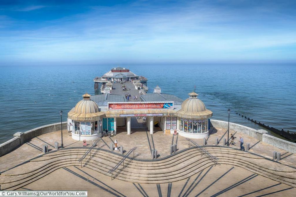 Looking down from the clifftop promenade to the elegant Cromer Pier reaching out to sea on a bright summer's day.