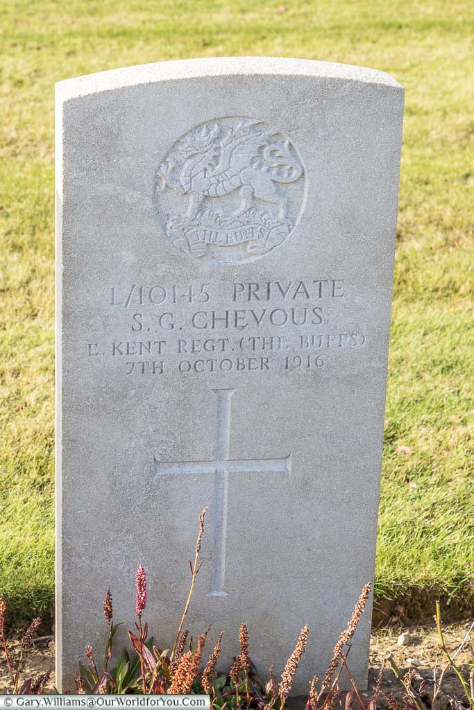 A Commonwealth War Graves Commission headstone for Sydney G Chevous of the Kent Buffs in the Bancourt British Cemetery, France