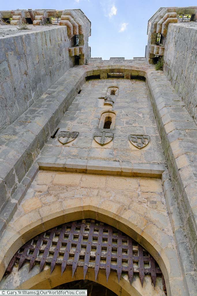 Looking up at the iron portcullis set in the massive stone entrance tower of Bodiam Castle