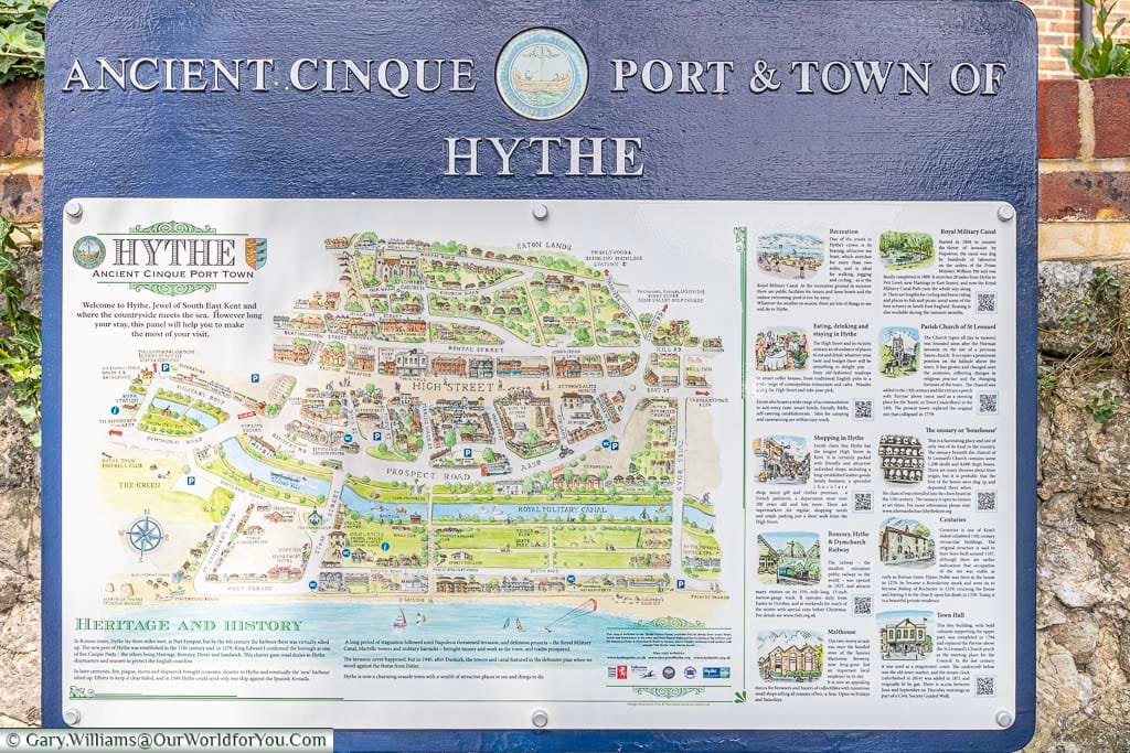 A tourist information board on the street with a map of the old town and key points of interest in Hythe