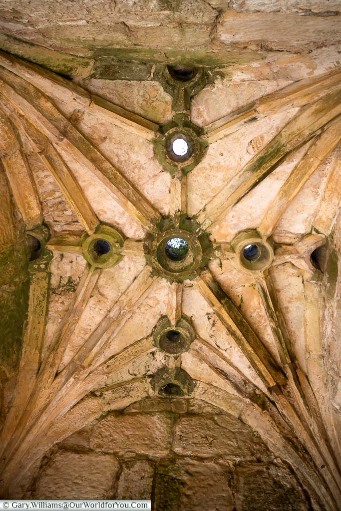 Looking up at the ‘Murder Hols’ in the vaulted stone ceiling of the entrance gatehouse of Bodiam Castle through which molten tar was poured on invaders.