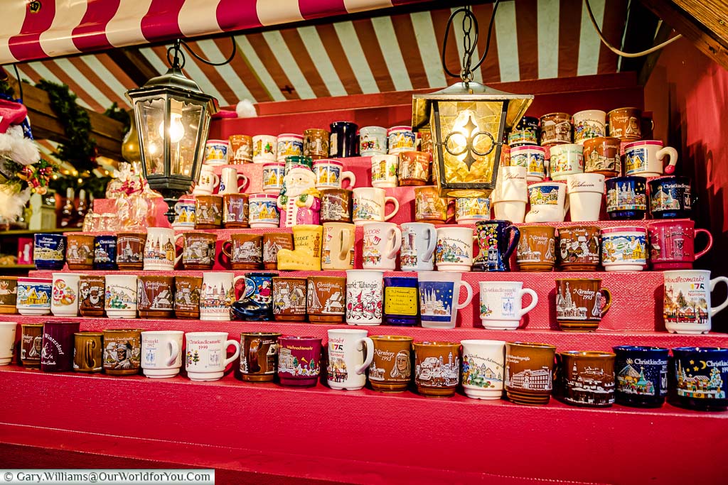 A stall with rows of tiered shelves of glühwein mugs on Nuremberg's Christmas Market
