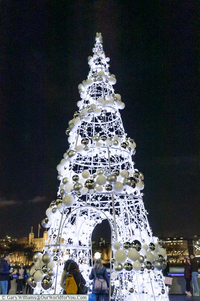 The Christmas Tree at London’s City hall is a giant framework cone with a walkway through the centre illuminated with hundreds of white fairy lights, and a spiral of white & gold baubles from the top.