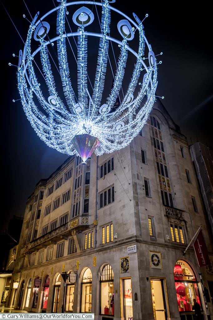 A giant illuminated Christmas decoration hanging over New Bond Street
