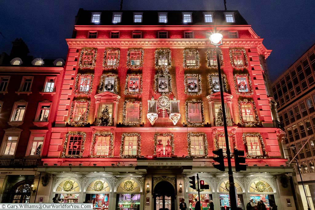 London’s favourite food store, Fortnum & Mason’s, decorated for Christmas as a giant advent calendar, illuminated in a festive red colour.