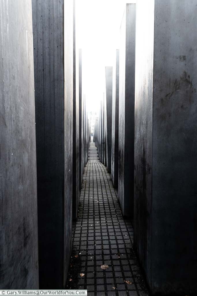 A view along the columns of the Berlin Holocaust Memorial towards a bright light