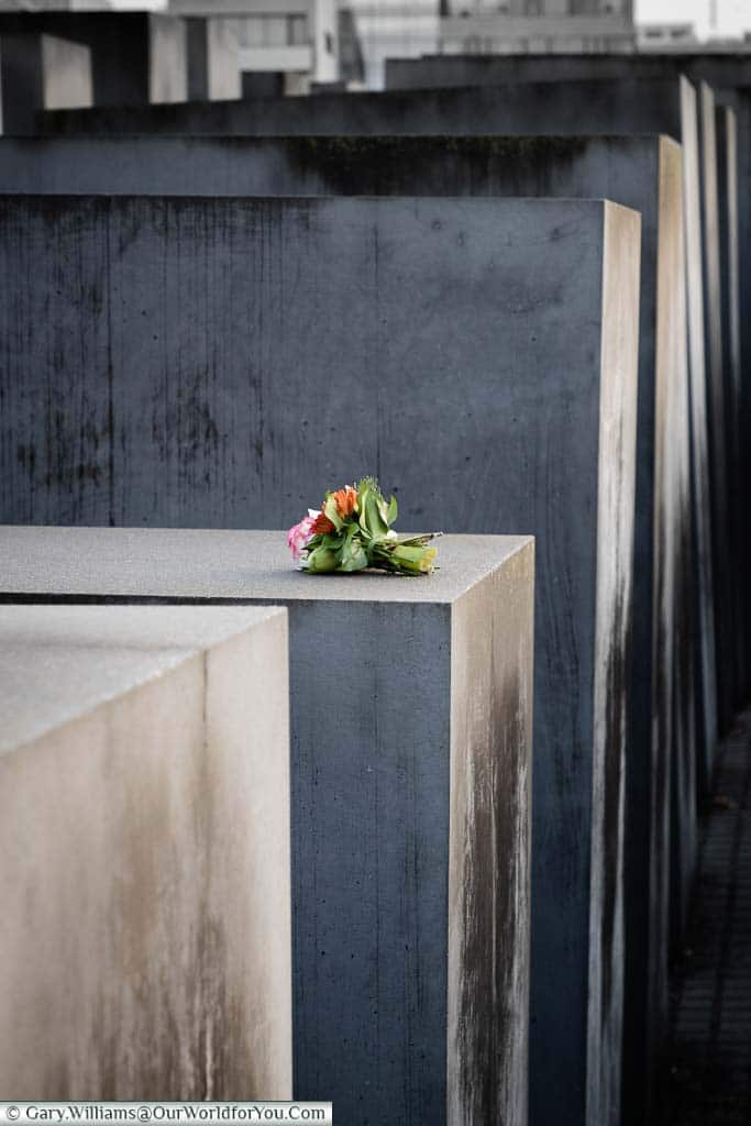 A small bunch of flowers left atop one of the grey concrete columns of the Holocaust Memorial in Berlin