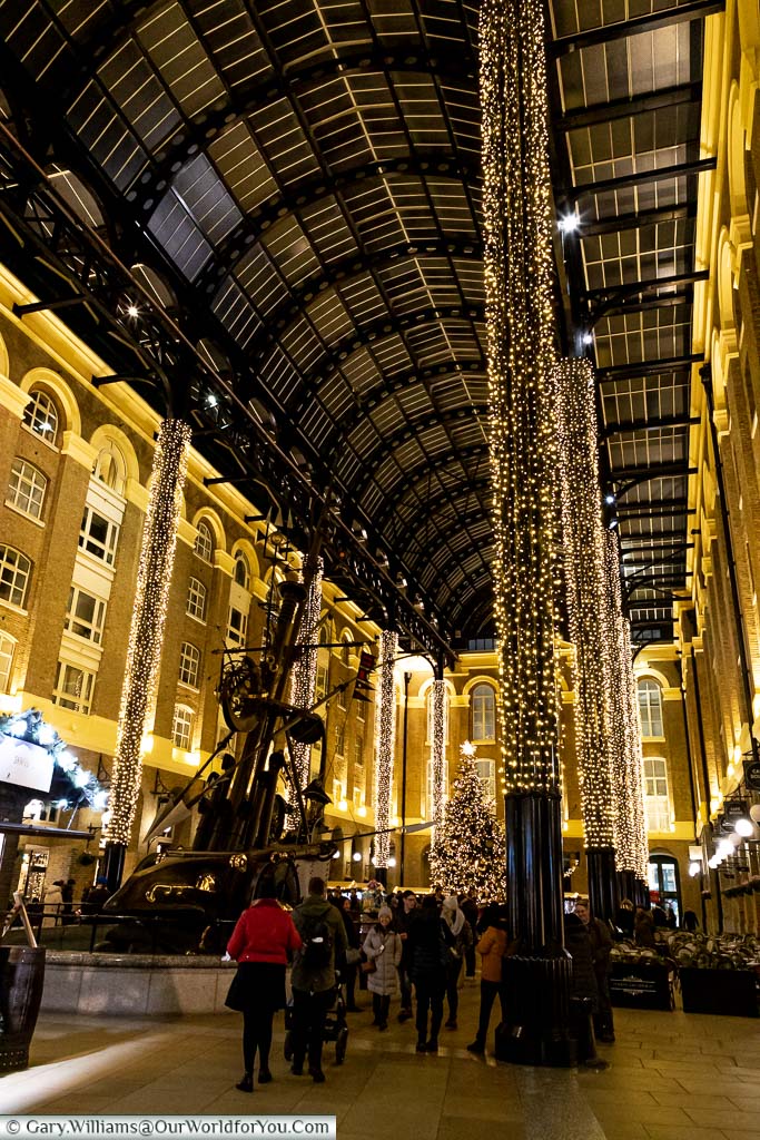 The view of Hay’s Galleria at Christmas with its giant iron pillars decorated with fairy lights.