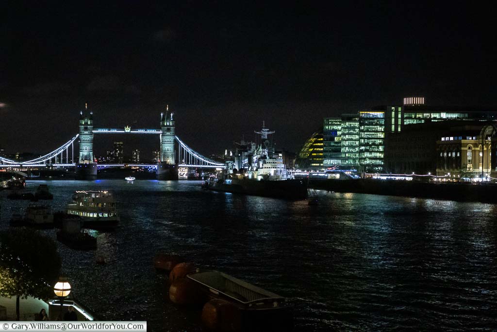 A view from London bridge across the River Thames to HMS Belfast, a large battleship and Tower Bridge and the Southside of the River which houses another Christmas market