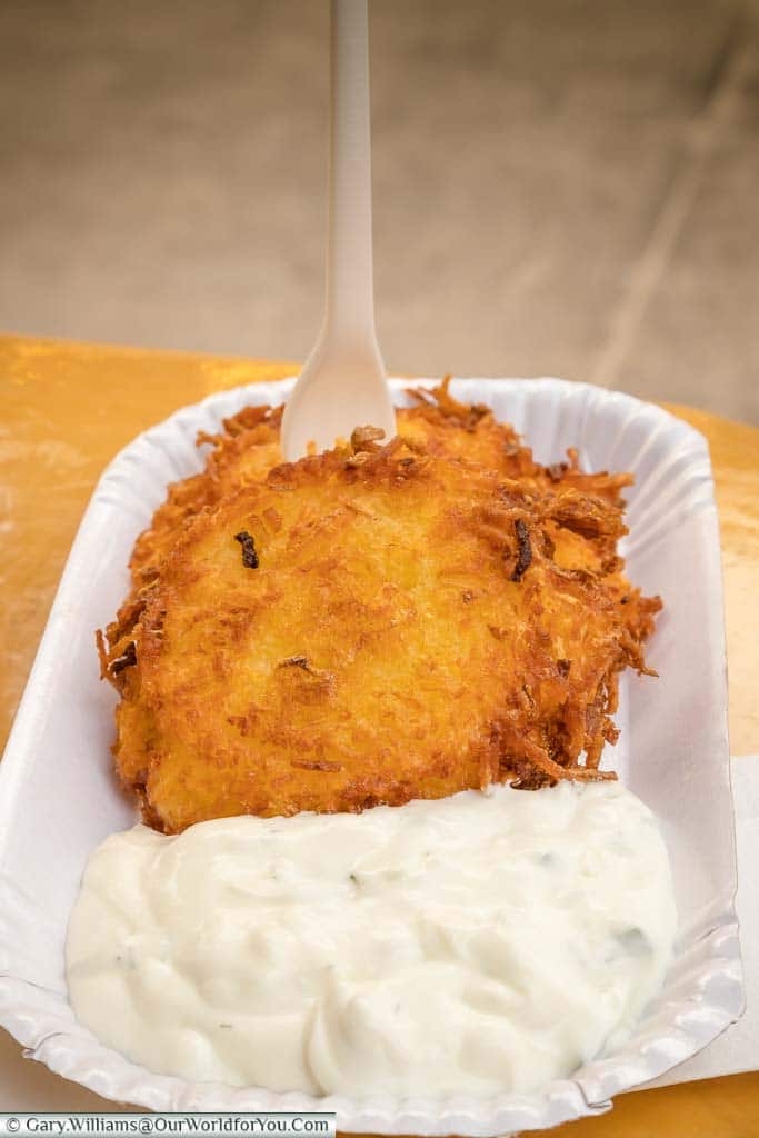 Potato cakes served with sour cream in a paper tray on Stuttgart Christmas Markets.