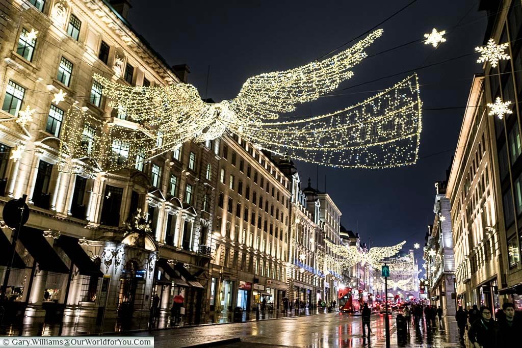 A view along Regent street with its illuminated Christmas Angels outstretched between either sides of the wide shopping street.