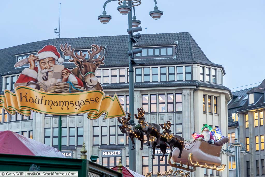 A real Santa is sitting in a sleigh drawn by four plastic reindeer that 'flies' above the Rathaus market in Hamburg.