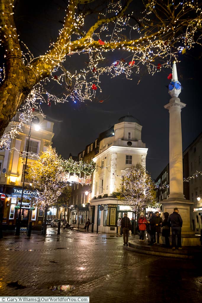 The column at the centre of Seven Dials surrounded by Christmas lights