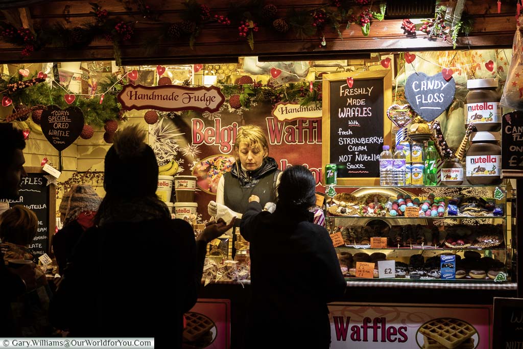 A family buying waffles from a stall on the Christmas Market at Tate Modern on Bankside