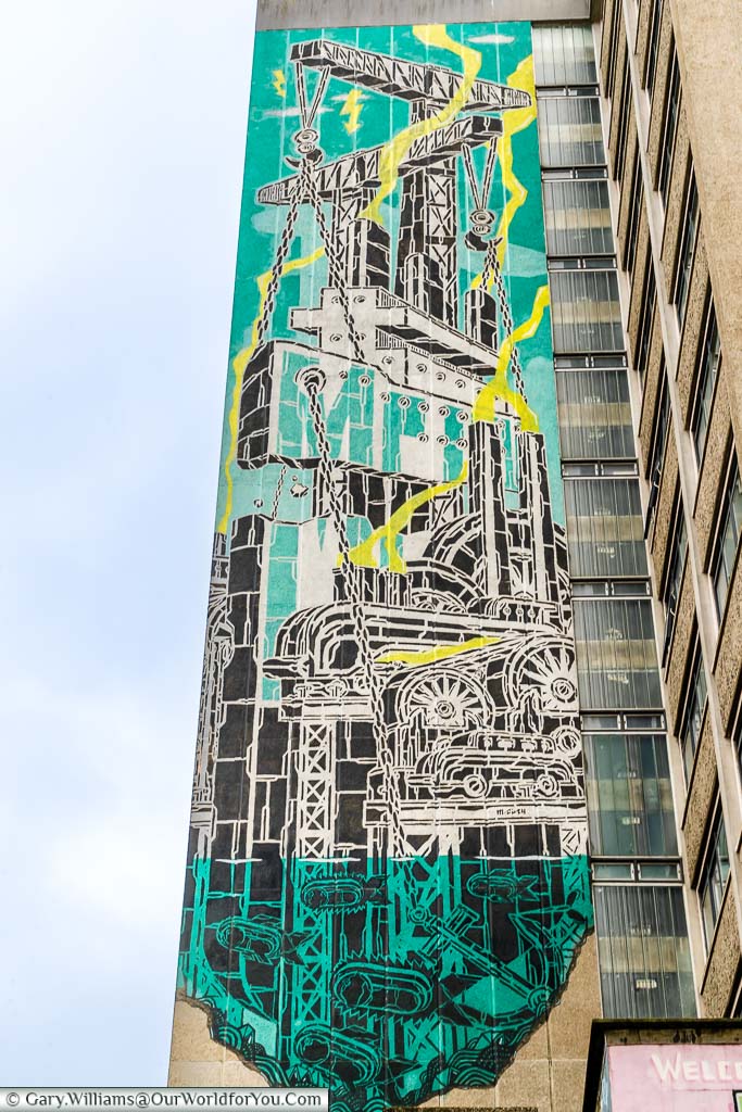 A construction scene mural on the side of a towerblock in Bristol