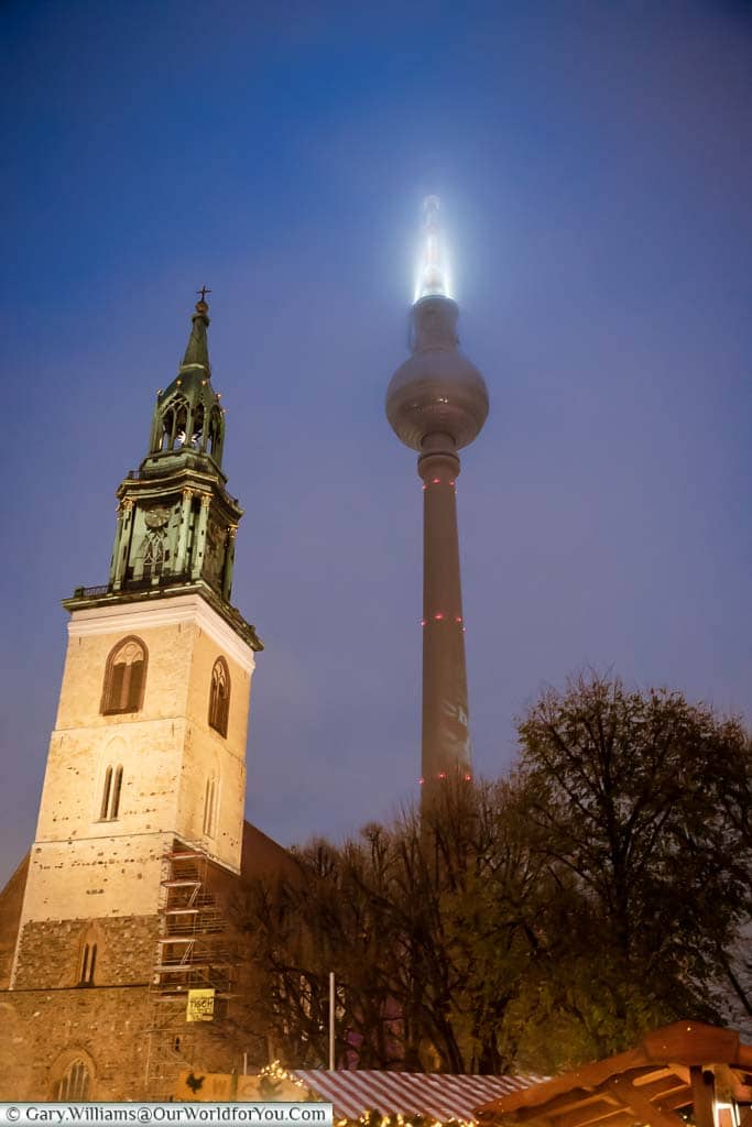 The tower of St. Mary's Church with the Berlin TV Tower in the background at Christmas