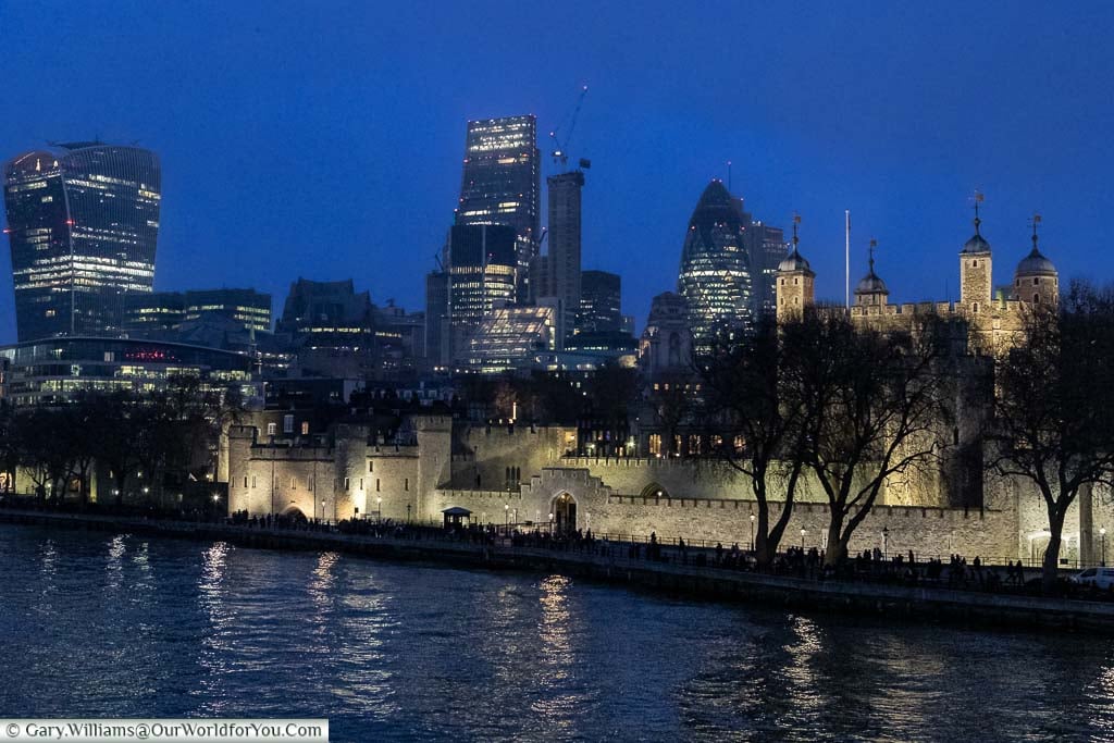 The River Thames in front of the Tower of London against the backdrop of the skyscrapers of the City of London at dusk