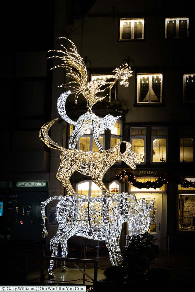 A fairy light statue to the Town Musicians of Bremen outside a café.