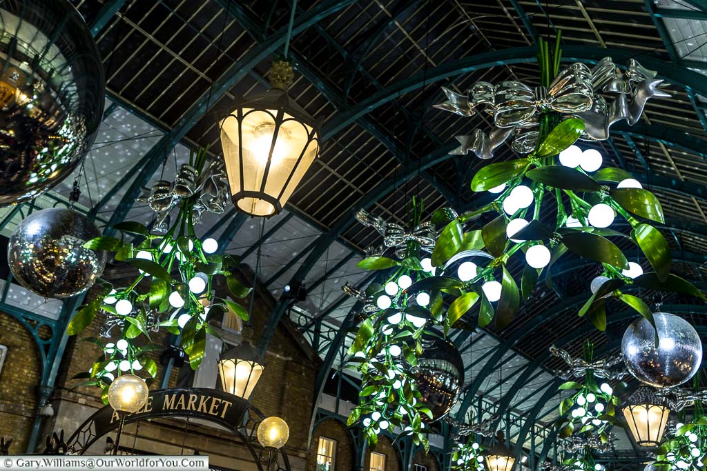 Christmas illuminations in Covent Garden in the shape of giant bunches of mistletoe bound by silver ribbons.