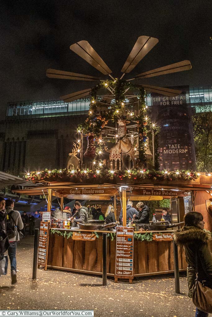 A giant wood Christmas pyramid above a food stall at the Tate Modern Christmas Market