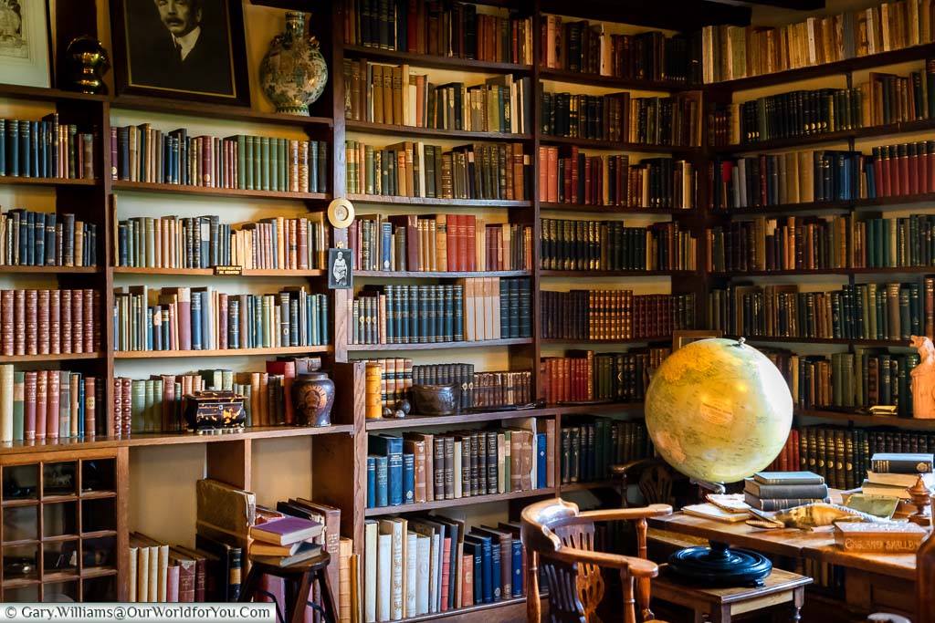 A large globe in the study at Bateman's surrounded by book-lined shelves