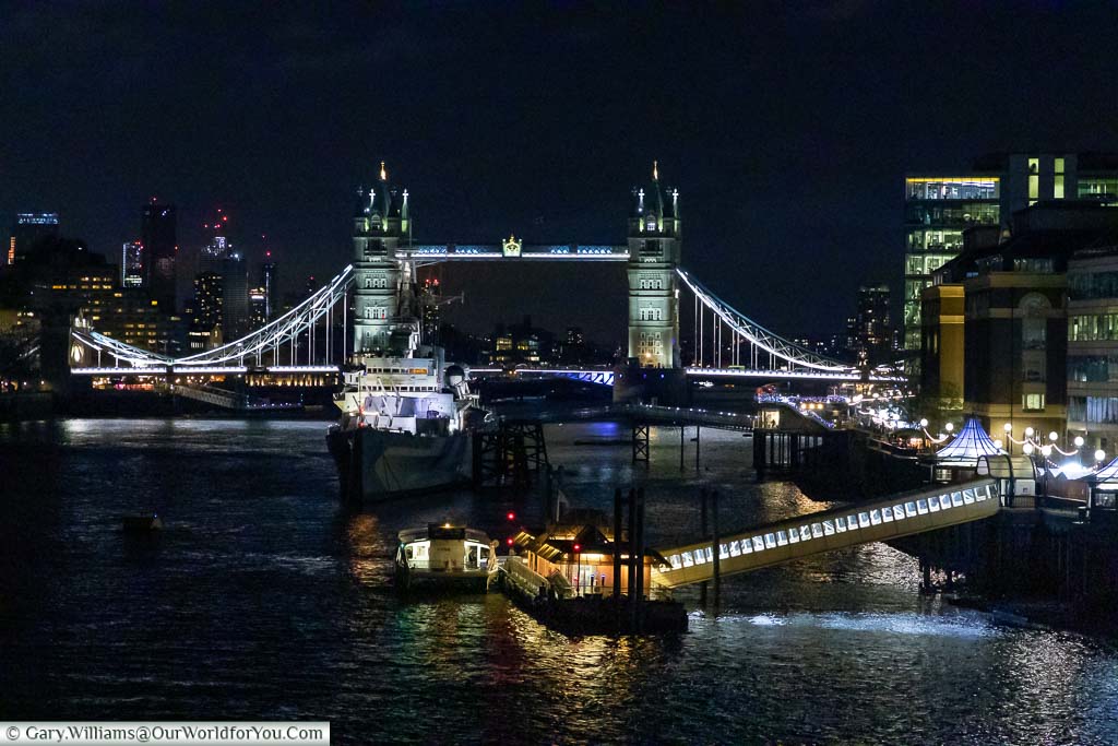 The lit Tower Bridge at night, and iconic London backdrop.