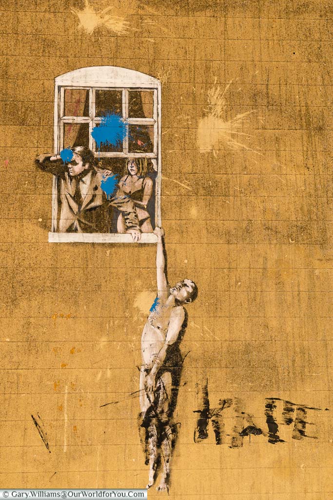 The stencilled art work 'Well Hung Lover' by Banksy of a naked man hanging from a window in Bristol