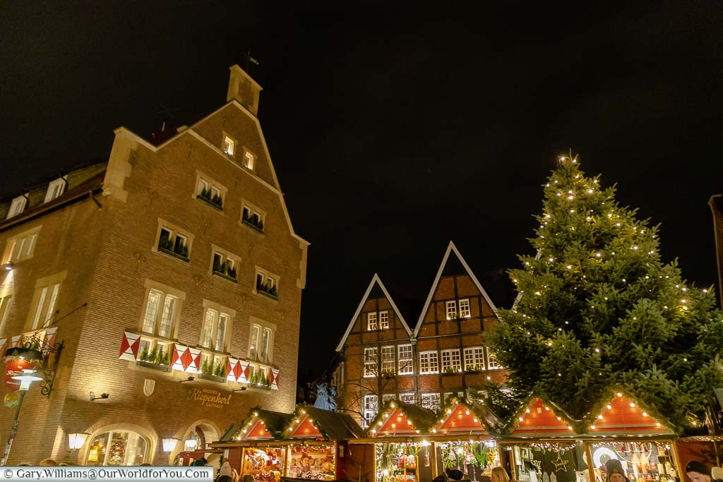 Christmas market huts under the giant Christmas tree in the Kiepenkerl Christmas village in Münster, Germany