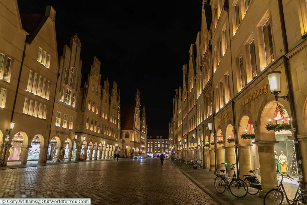 The impressive historic buildings on either side of the deserted cobbled street of Prinzipalmarkt running through the centre of Münster at night