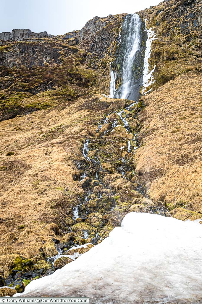 A small waterfall trickling down the cliff endge a short distance from Seljalandsfoss