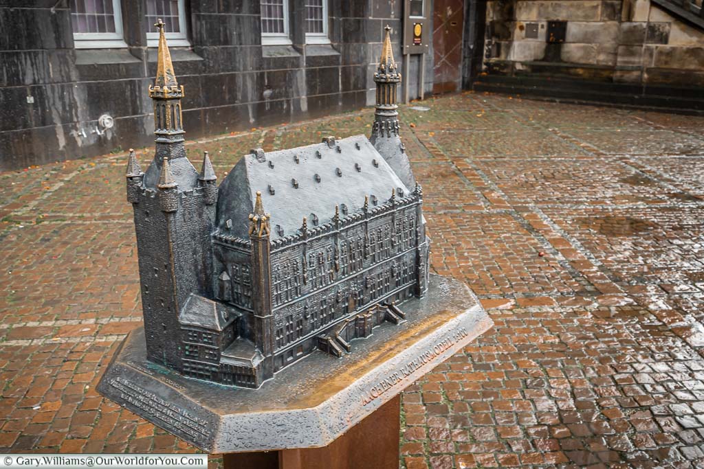 A brass model of Aachen's Rathaus on a plinth outside the acutal Rathaus.