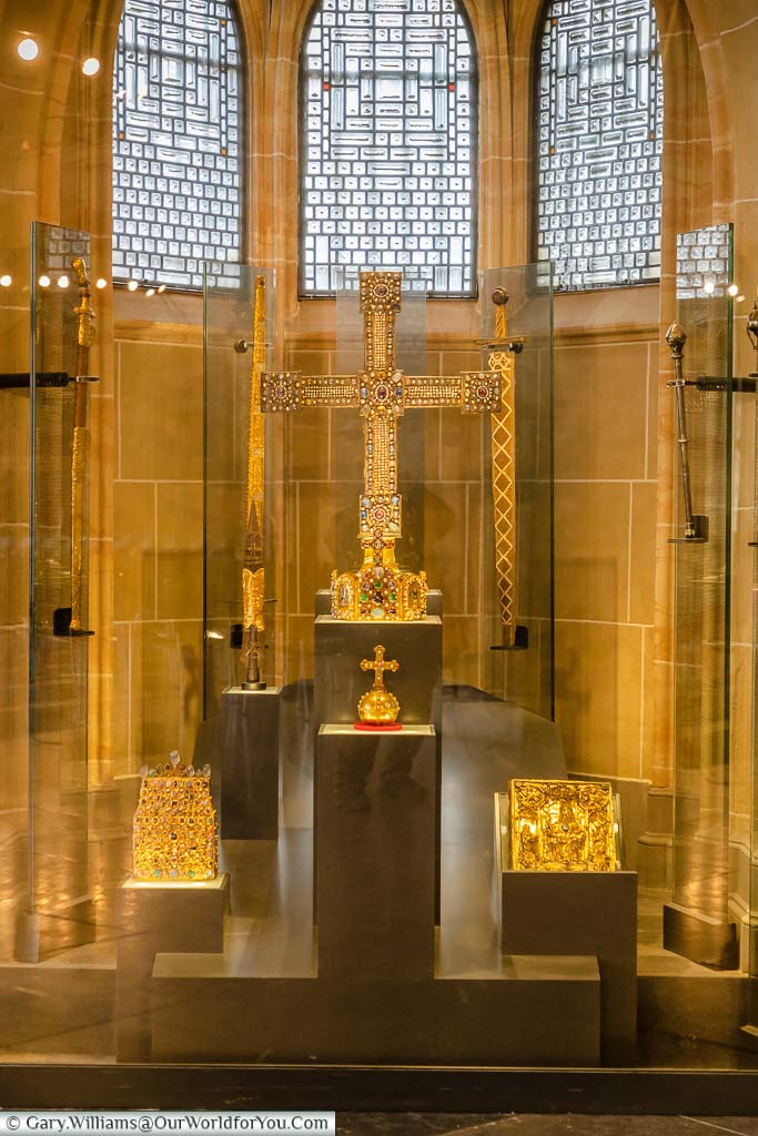 A glass cabinet in Aachen's Coronation Hall containing the gold ceremonial Imperial Regalia