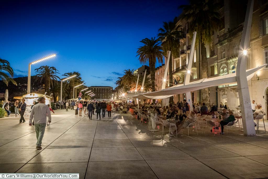 People enjoying a stroll along the Riva in Split after sundown.
