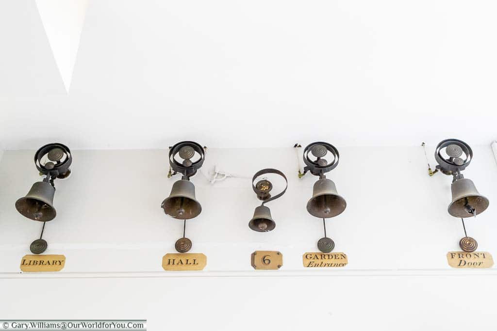 A row of brass room bells in the kitchen of Scotney House