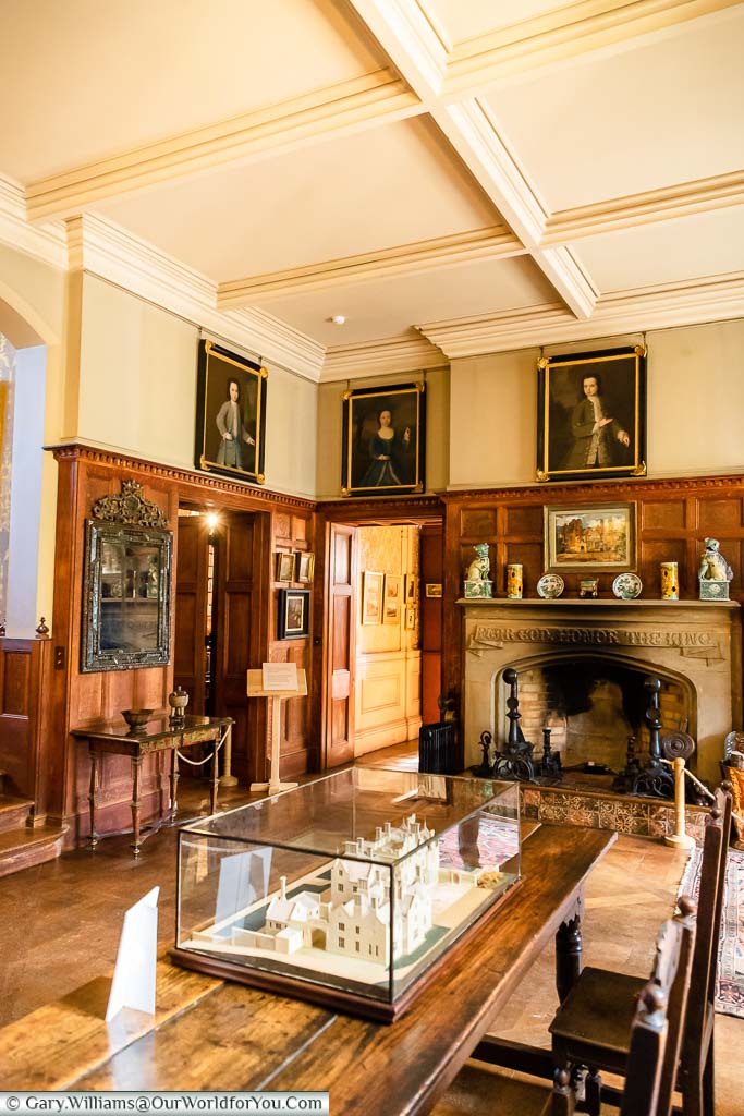 The traditional wood-panelled entrance hall at Scotney House with a large stone fireplace
