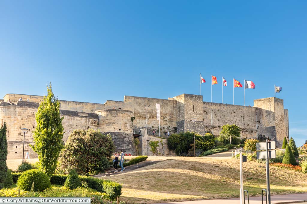 Looking towards the walls of the Château de Caen under a bright blue sky with alternating French & Normandy flags fluttering in the evening breeze.
