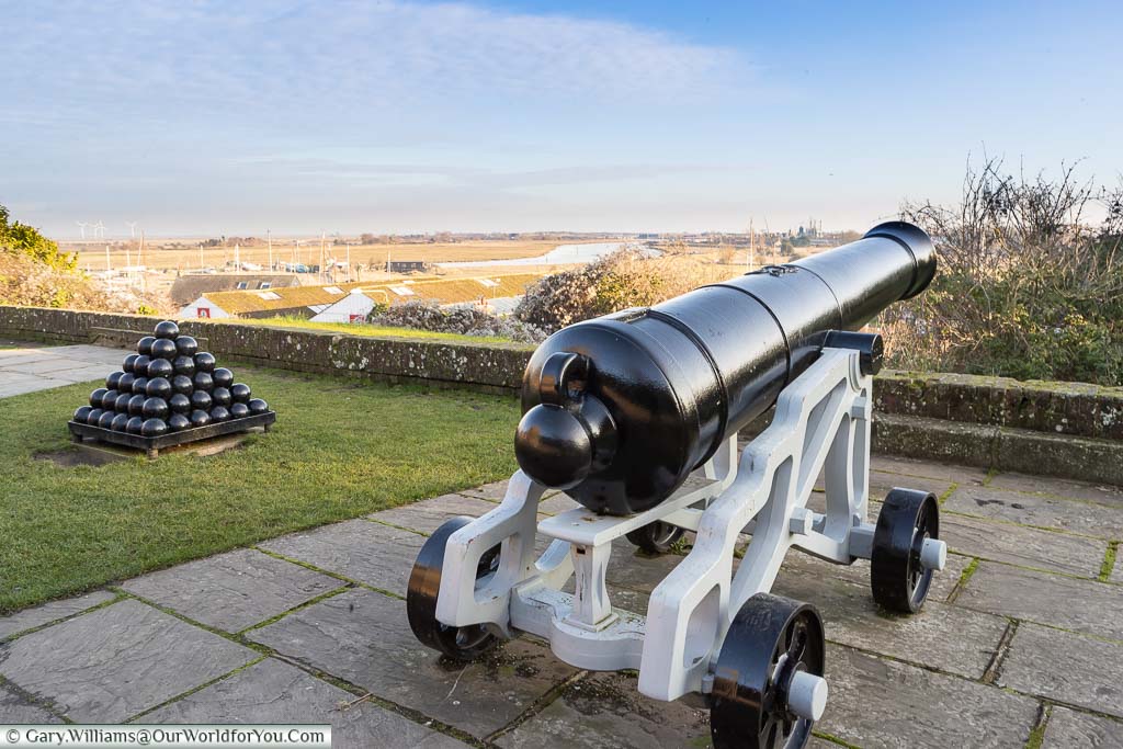 A cannon and cannonballs in the Gun Garden overlooking the River Rother as it flows past Rye