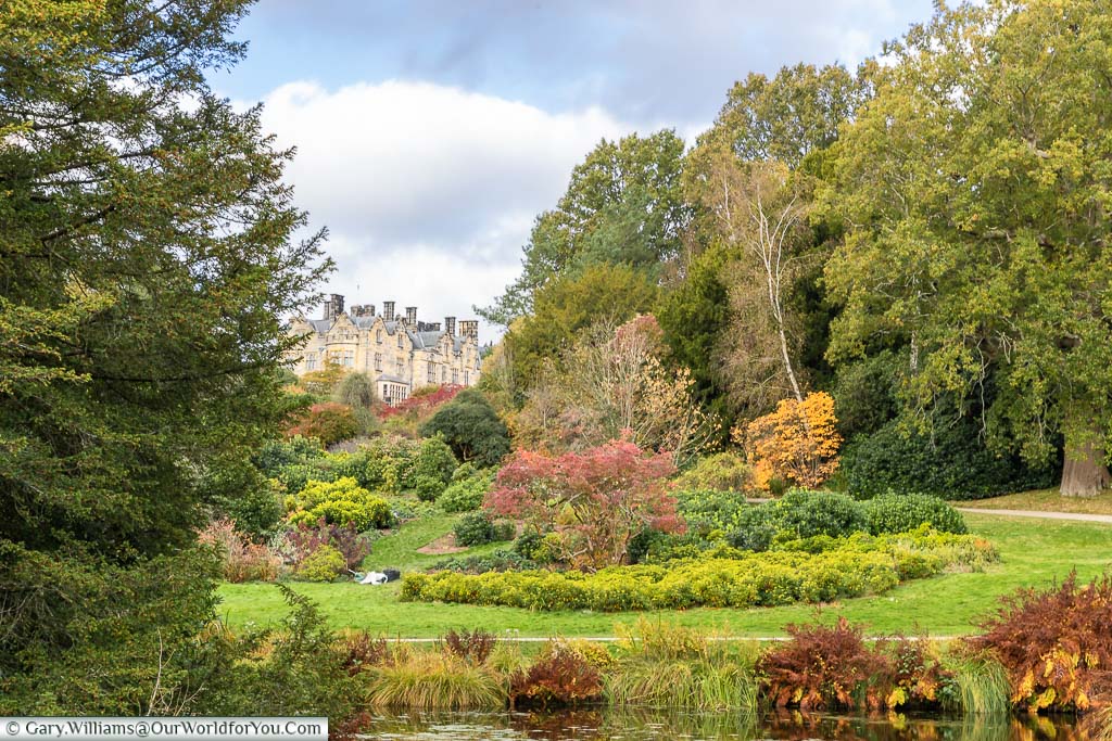 A view across the gardens of Scotney Castle over the pond to Scotney House on the hill