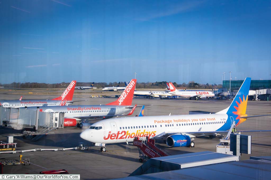 Three Jet2 Planes parked at their gates at Stansted airport on a clear day with Blue skies