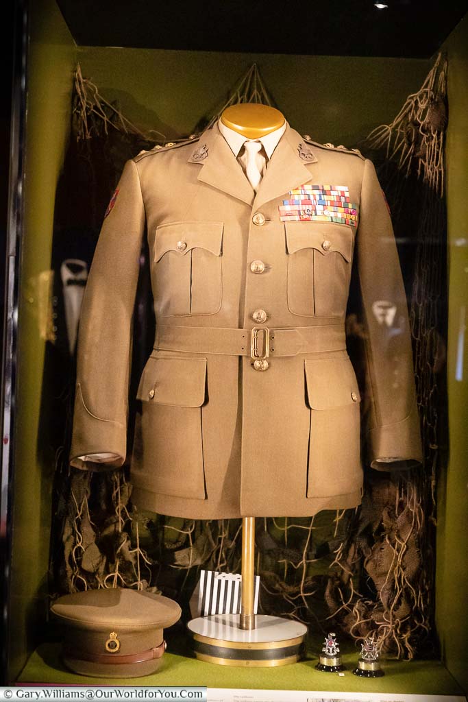 A buff-coloured military jacket, embellished with many medal ribbons, and cap of Sir Winston Churchill in the Uniform Room within Chartwell House.