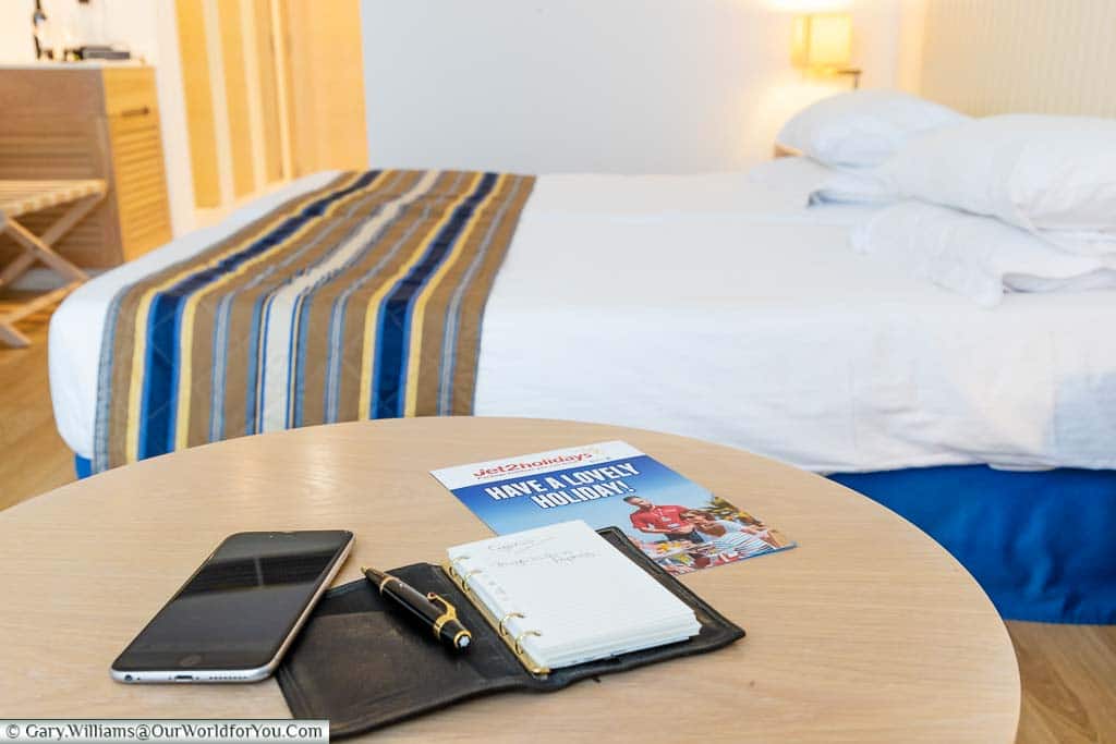 The Jet2Holidays welcome leaflet, Filofax, pen and mobile phone on our lounge table, in our room, at Olympic Lagoon Resort Paphos