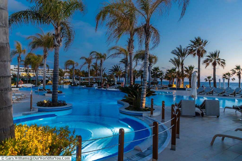 The interlinked circular pools at the Olympic Lagoon Resort Paphos as the sun goes down.