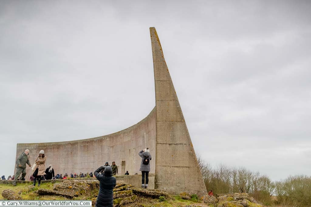 People taking pictures from the edge of the large concrete sound mirror on Romney Marsh
