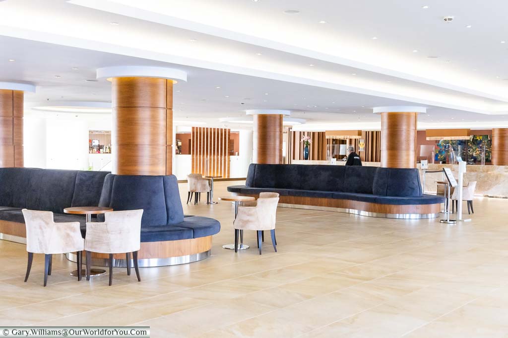 The bright and airy open reception area at Olympic Lagoon Resort Paphos doubles as a meeting place with seating.