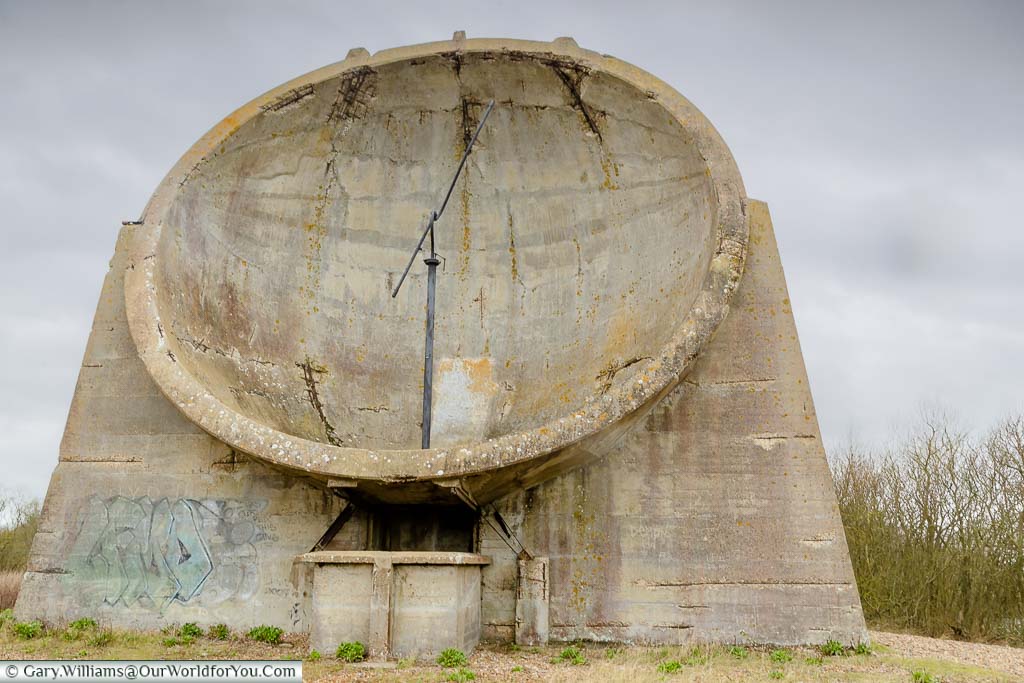A front-on view of the large circular concrete sound mirror, complete with listening rod, in the Romney Marshes in Kent