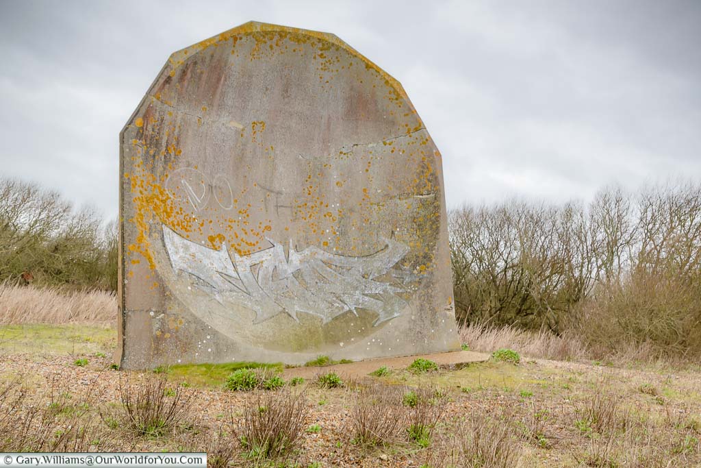 Looking straight at the small circular concrete sound mirror in the Romney Marshes, Kent
