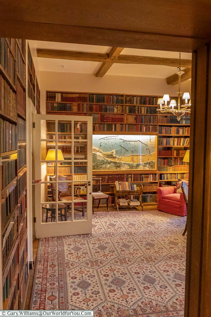 The bookshelf lined library at Chartwell house with a large map of the Port Arromanches in the centre of one wall.