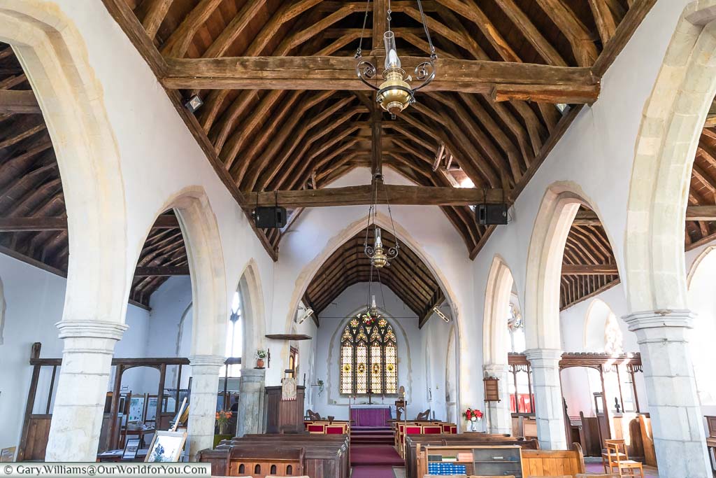 The inside of St Peter & St Paul's Church, Newchurch, with its wooden vaulted room resting on stone pillars.