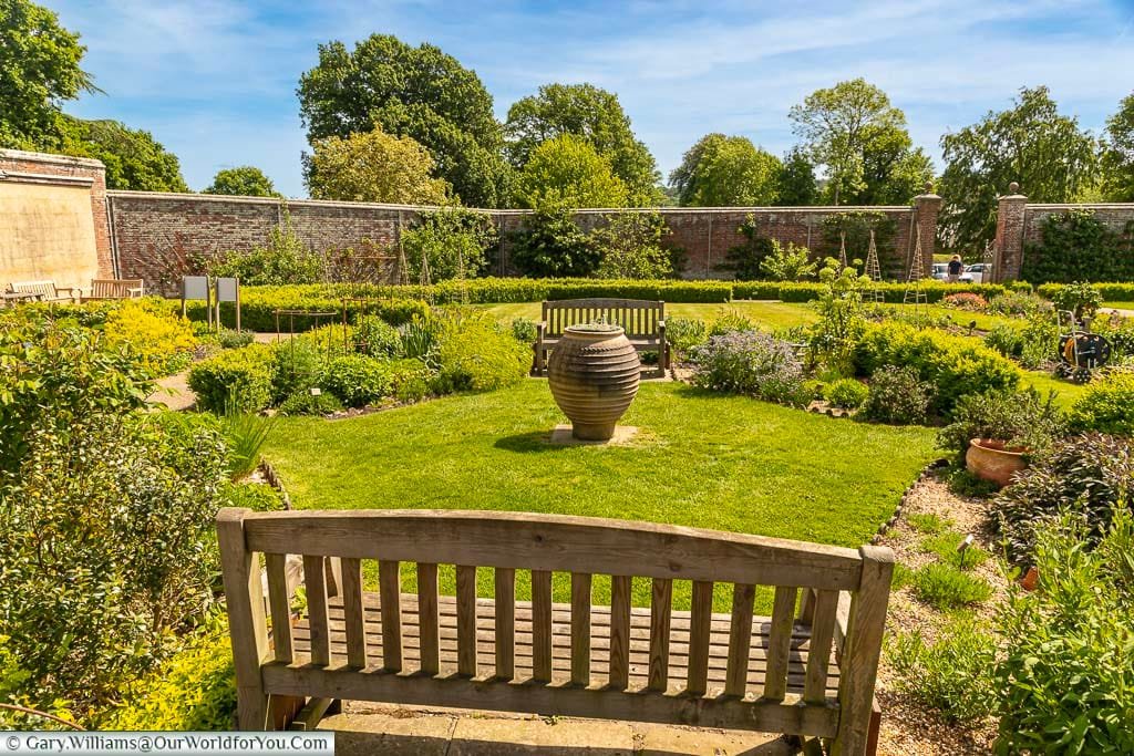 Two benches on either side a smaller herb garden within the more extensive walled Garden at Scotney Castle in Kent