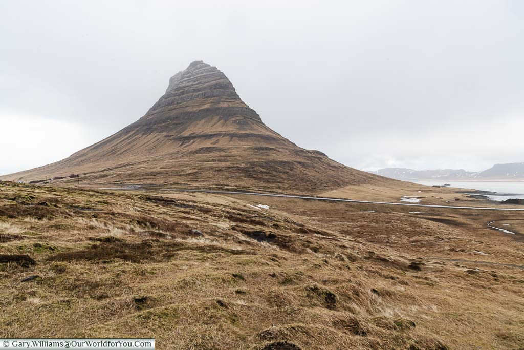 The dramatic, lone, peak of the Kirkjufell Mountain in the bleak landscape of northwestern Iceland
